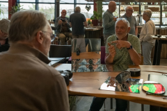 twee mannen praten aan een tafel met elkaar bij het fotocafe