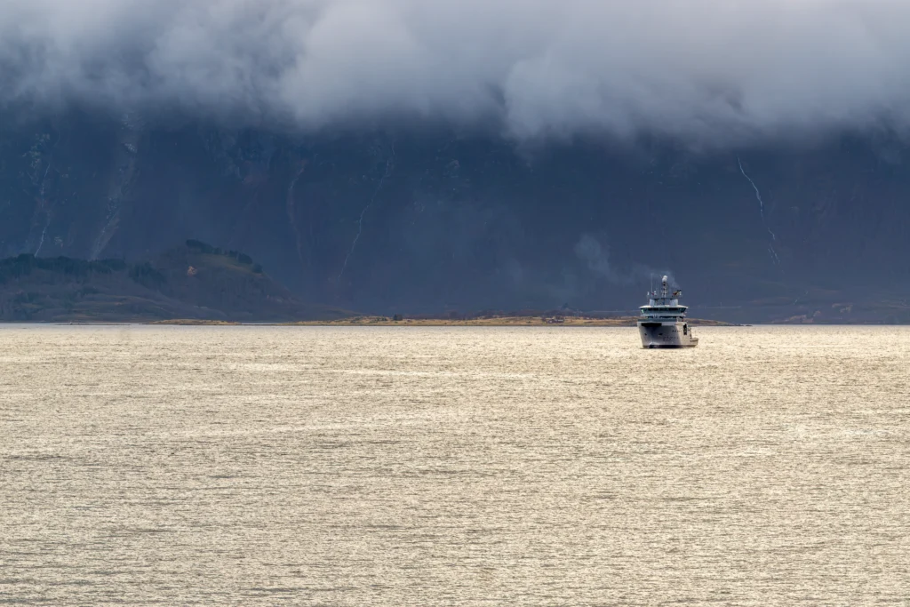 Noorwegen Schip op zee in de ondergaande zon met mist op de achtergrond