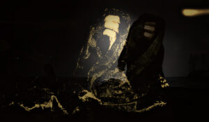 Een hand omgeven door een doek rijst omhoog uit het water. in het ochtdlicht. er is op het beeld een schaduw te zien in het donker en duidelijker in de contouren. Het heeft de titel ontwaken